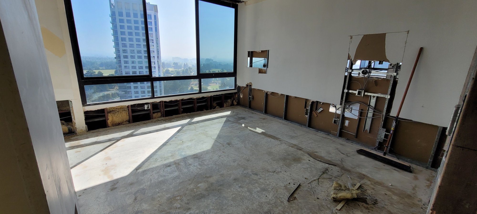 A corner room on the bare slab, with the drywall cut away along the base.