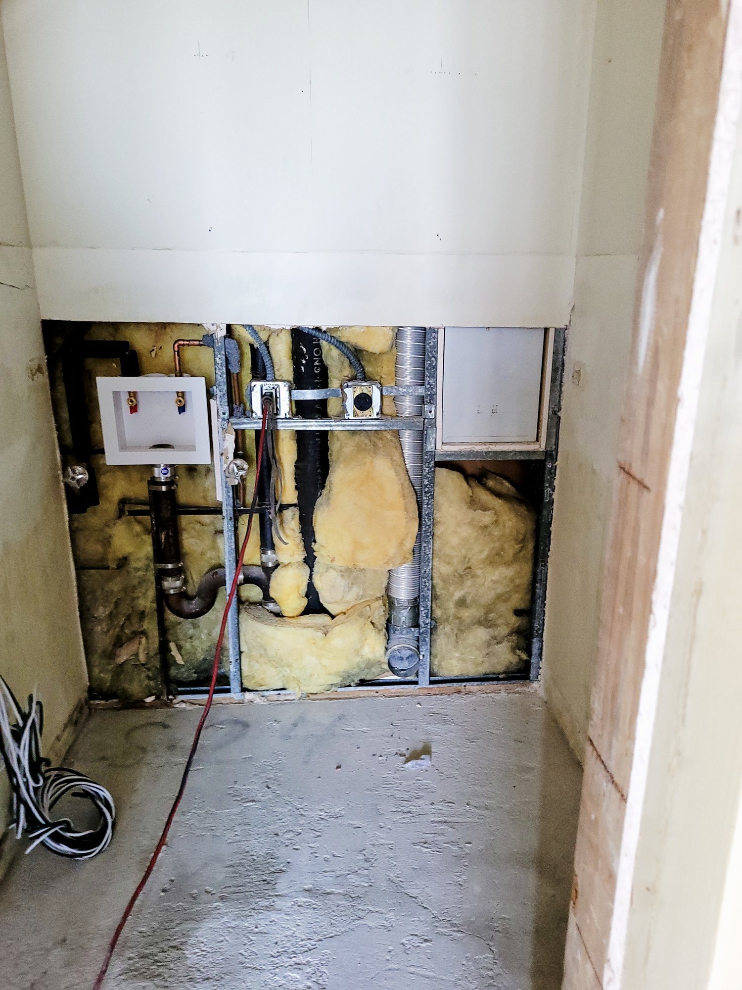 Laundry niche opened to the washer box, drain, dryer vent and electrical boxes.