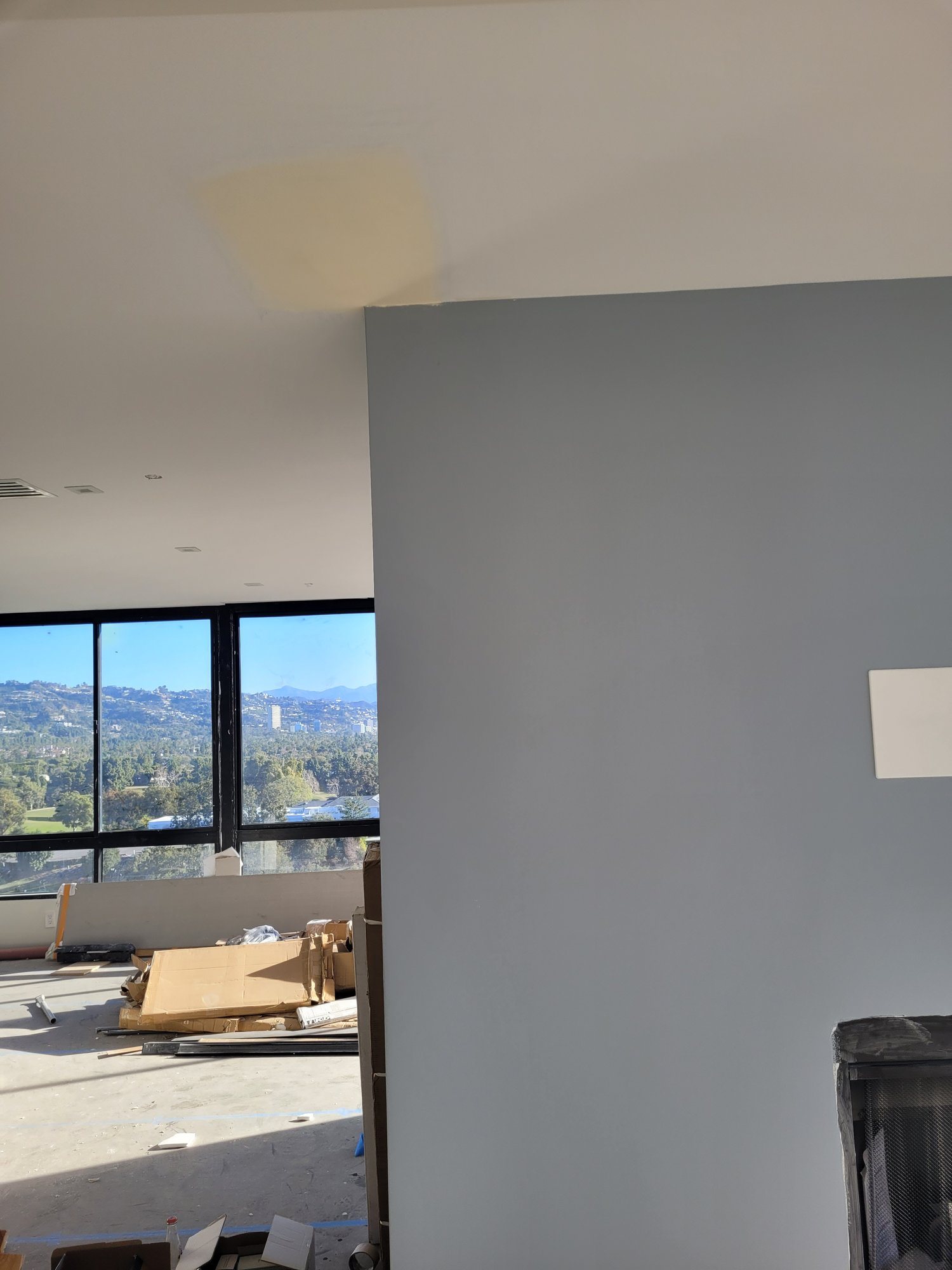 A new painted partition beside the living area, with the windows beyond.
