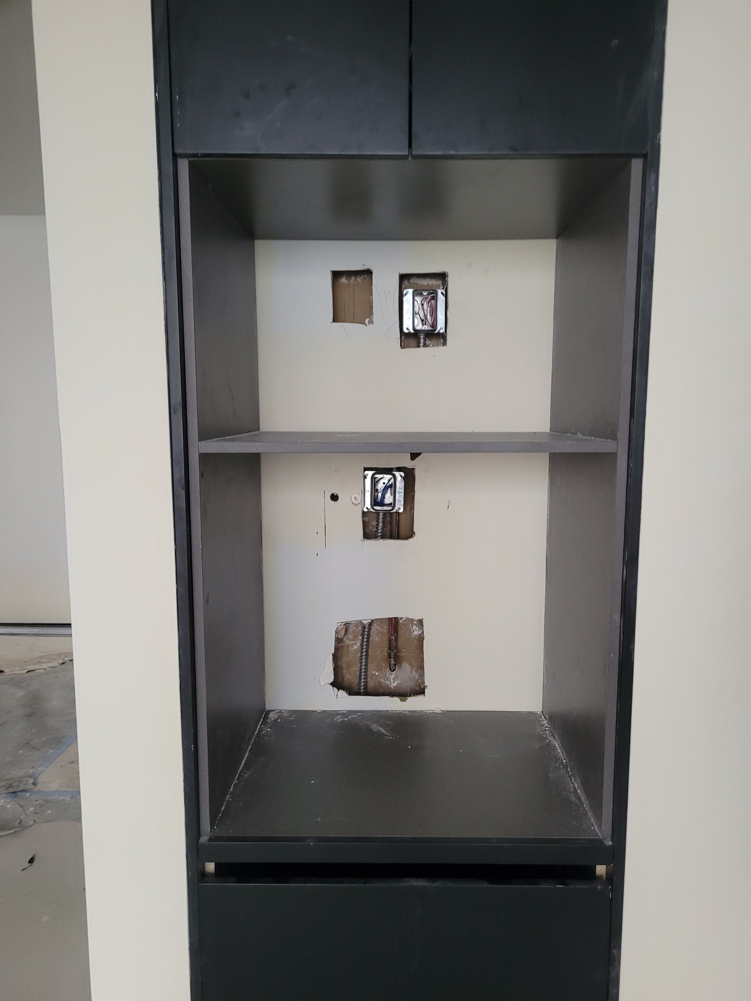 Power roughed in through the back of a tall built-in cabinet, ready for appliances.