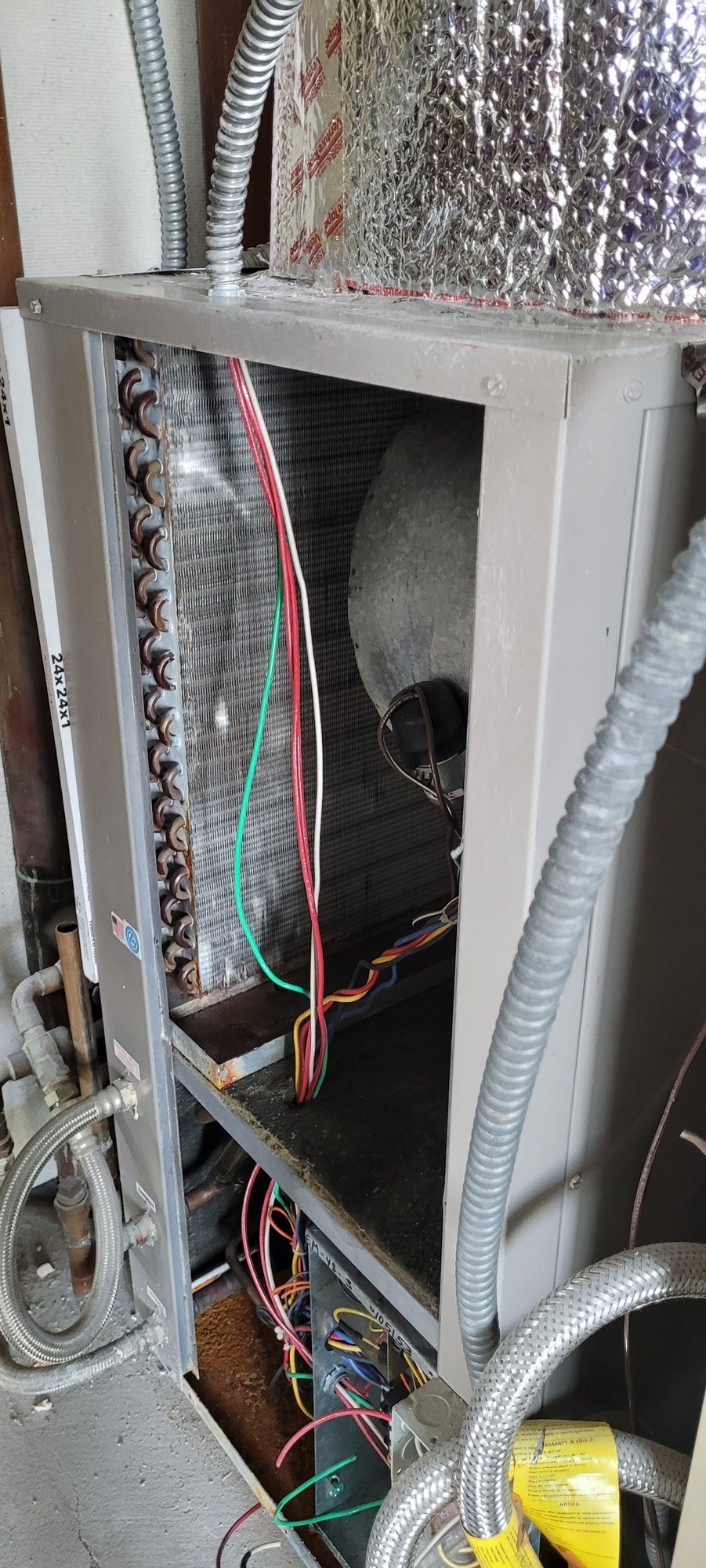 An existing fan coil unit opened up, with its coil, controls and water connections.